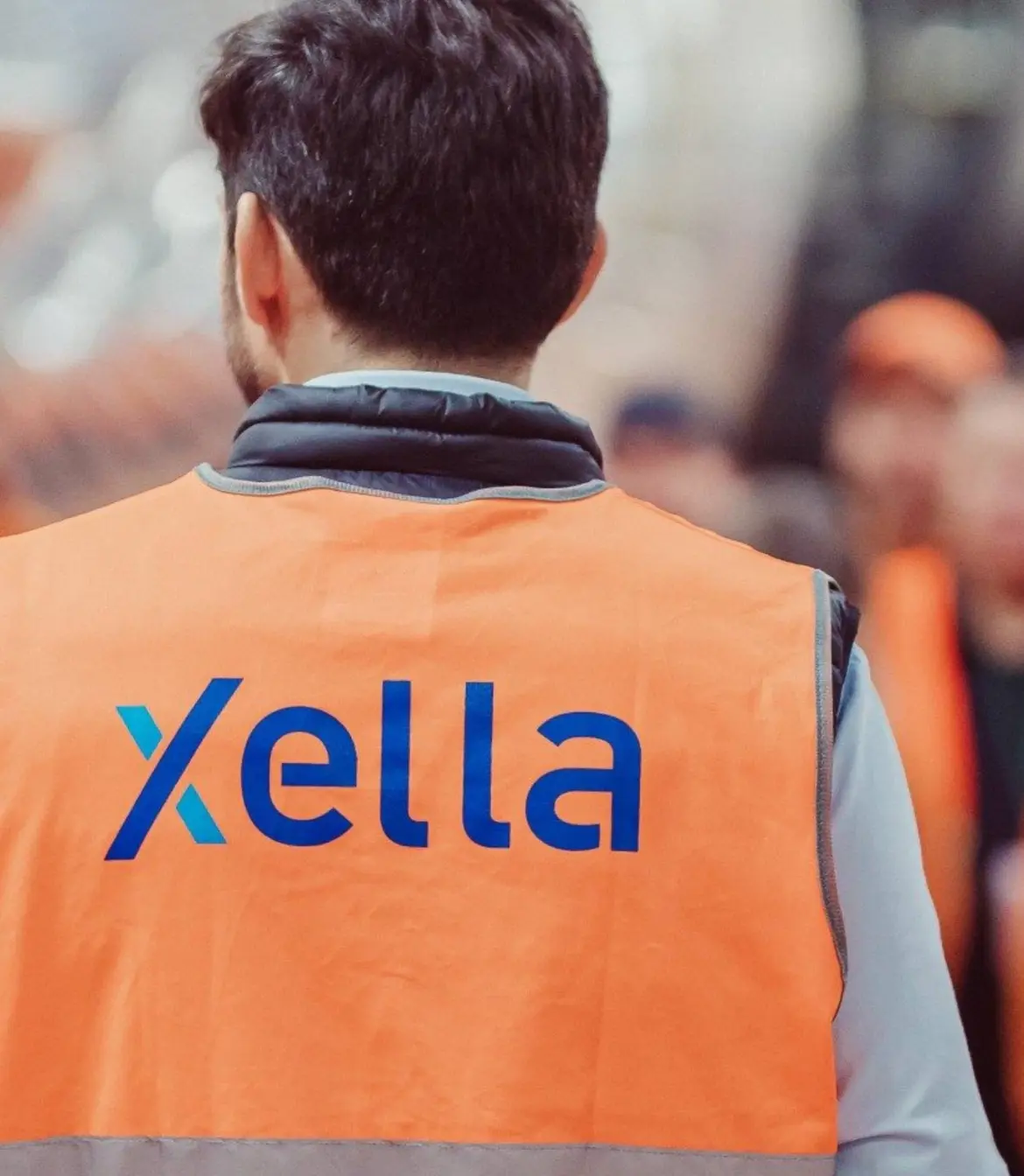 Team member wearing an orange Xella safety vest